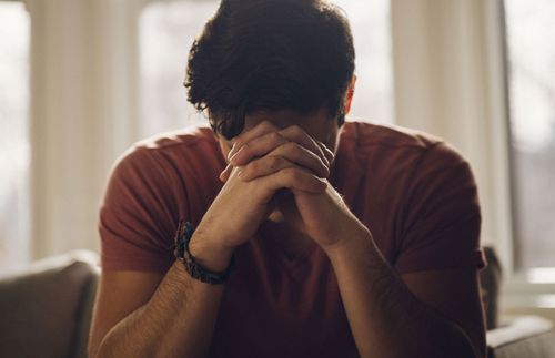 a man bowing his head and praying