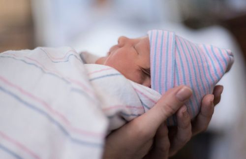 newborn baby wearing a striped cap