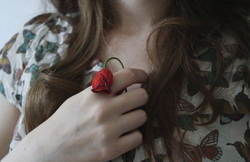 Woman holding rose to her chest