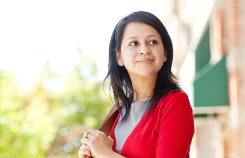 Portrait photograph of a young adult woman.  She is wearing a red sweater.