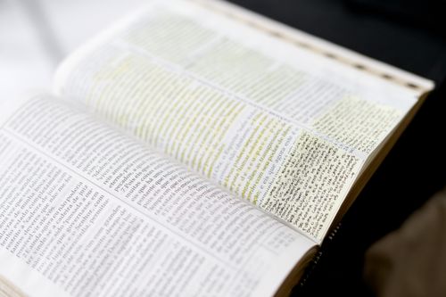 Hardbound Portuguese scriptures with yellow highlights and sticky notes.
