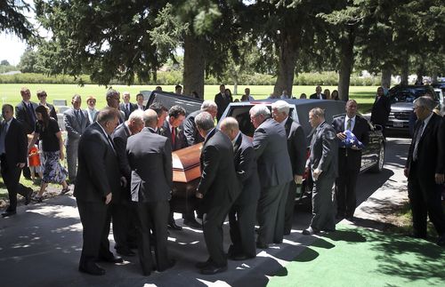 pallbearers lifting casket