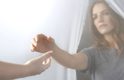 woman reaching out to extended hand