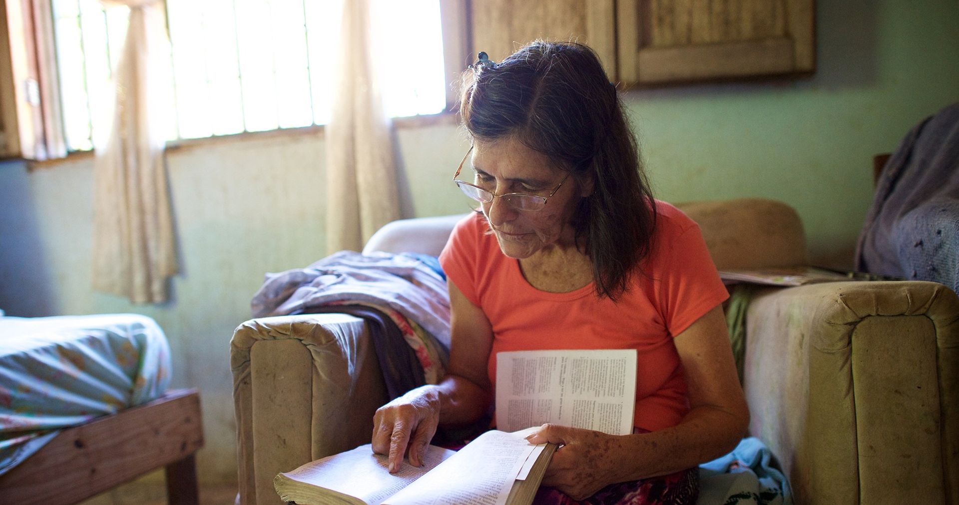 Adult female sitting reading scriptures.