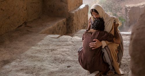 Jesus embraces the man who was born blind when the man finds him again after Jesus healed him.