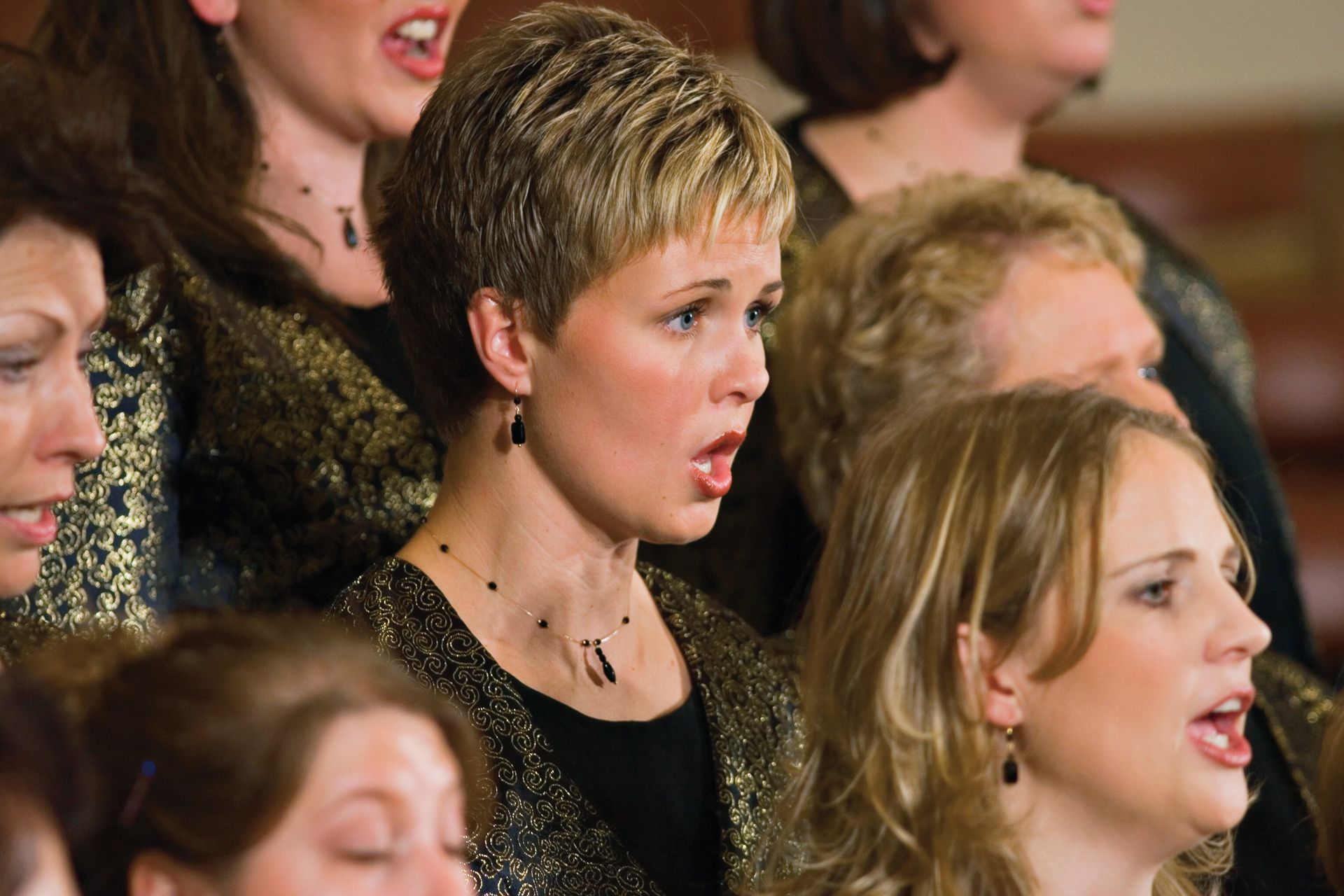 A group of women standing and singing in a women’s choir.