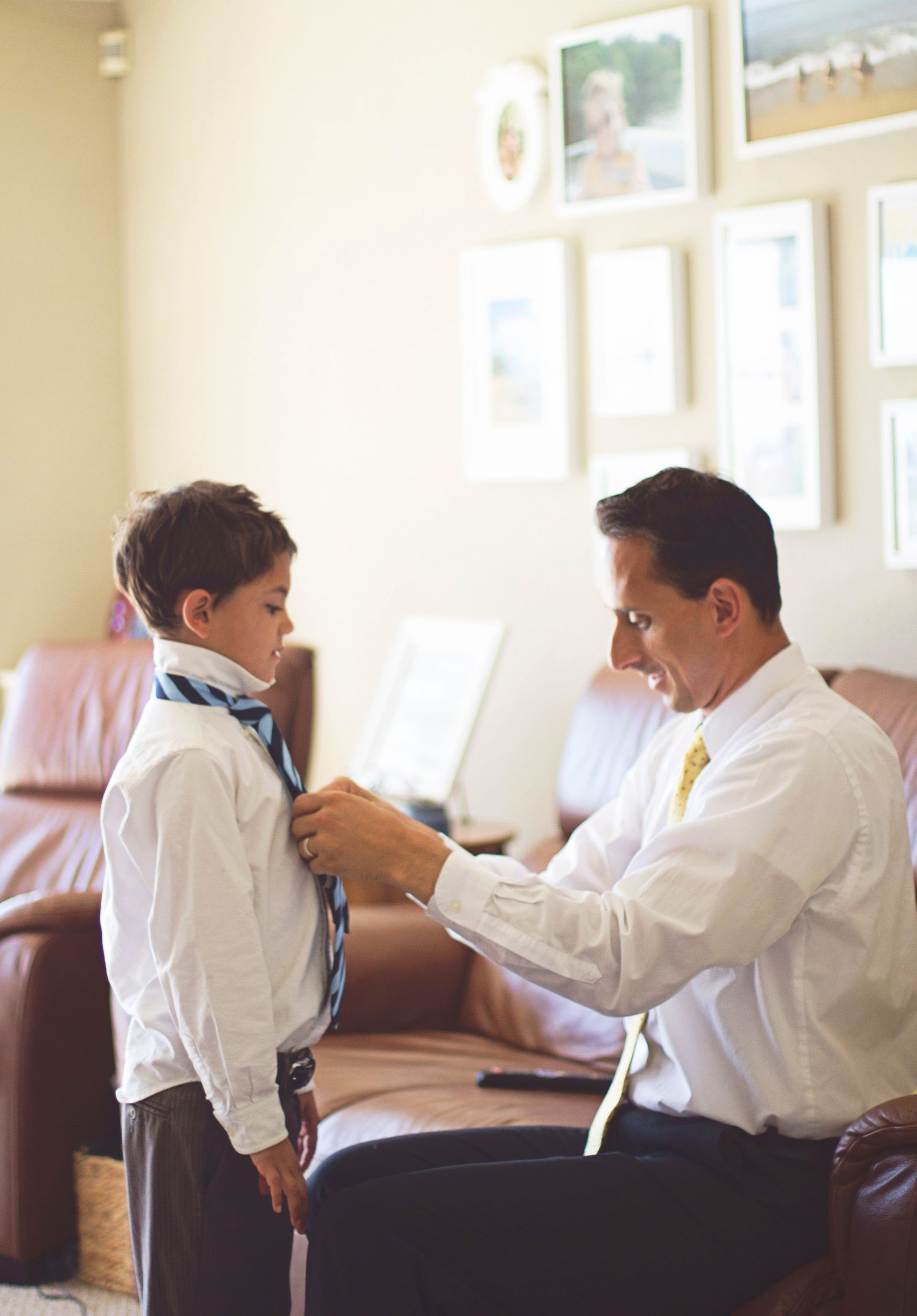 A father teaches his son how to tie a tie.