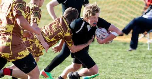 Young men playing rugby.