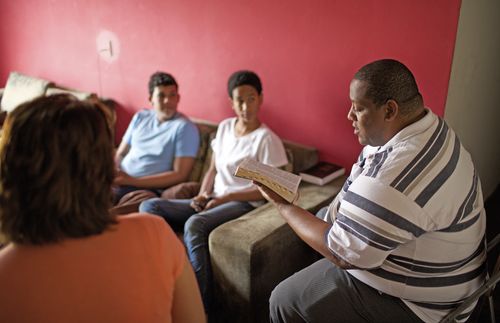 father reading scriptures to family