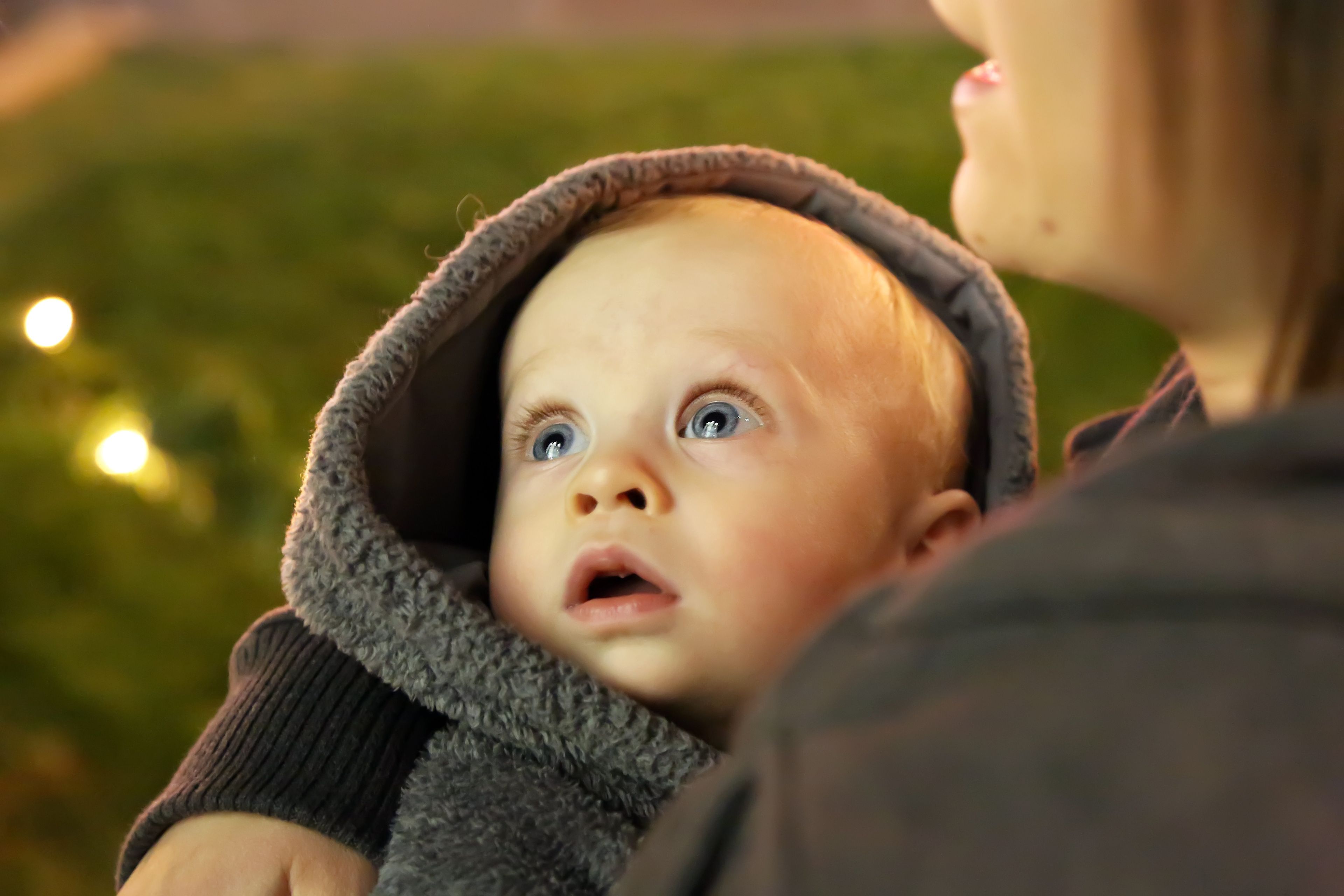 A baby looks up at the temple while being carried around Temple Square at Christmastime.