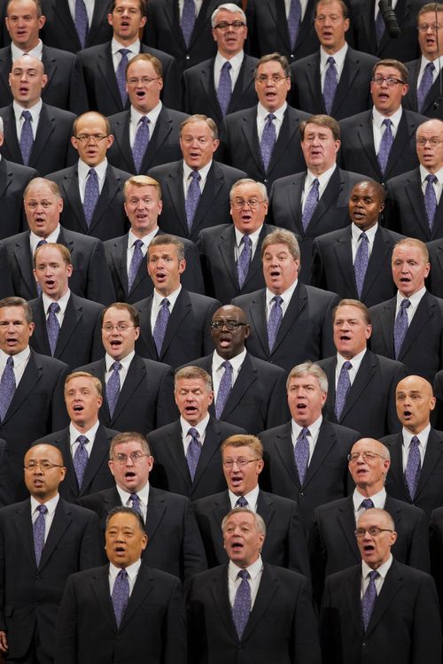 A group of men wearing black suits and purple ties, singing together at a session of the April 2013 general conference.