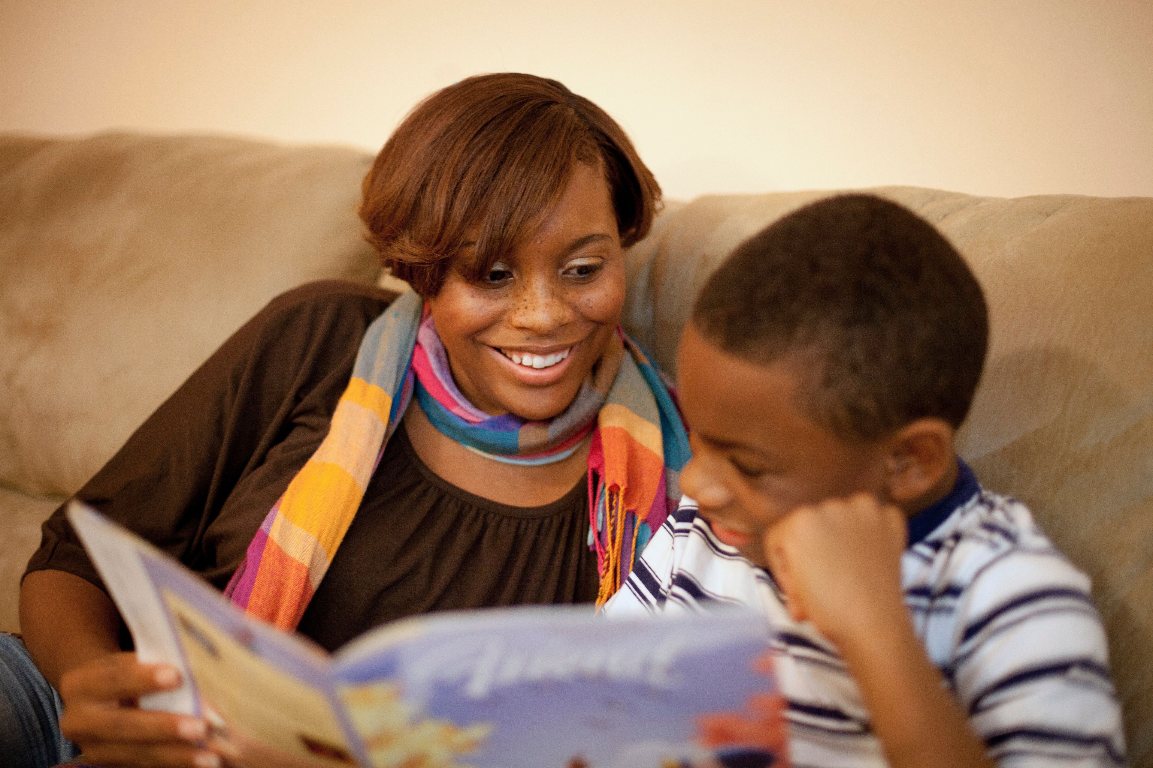 A mother reads the Friend magazine with her son.