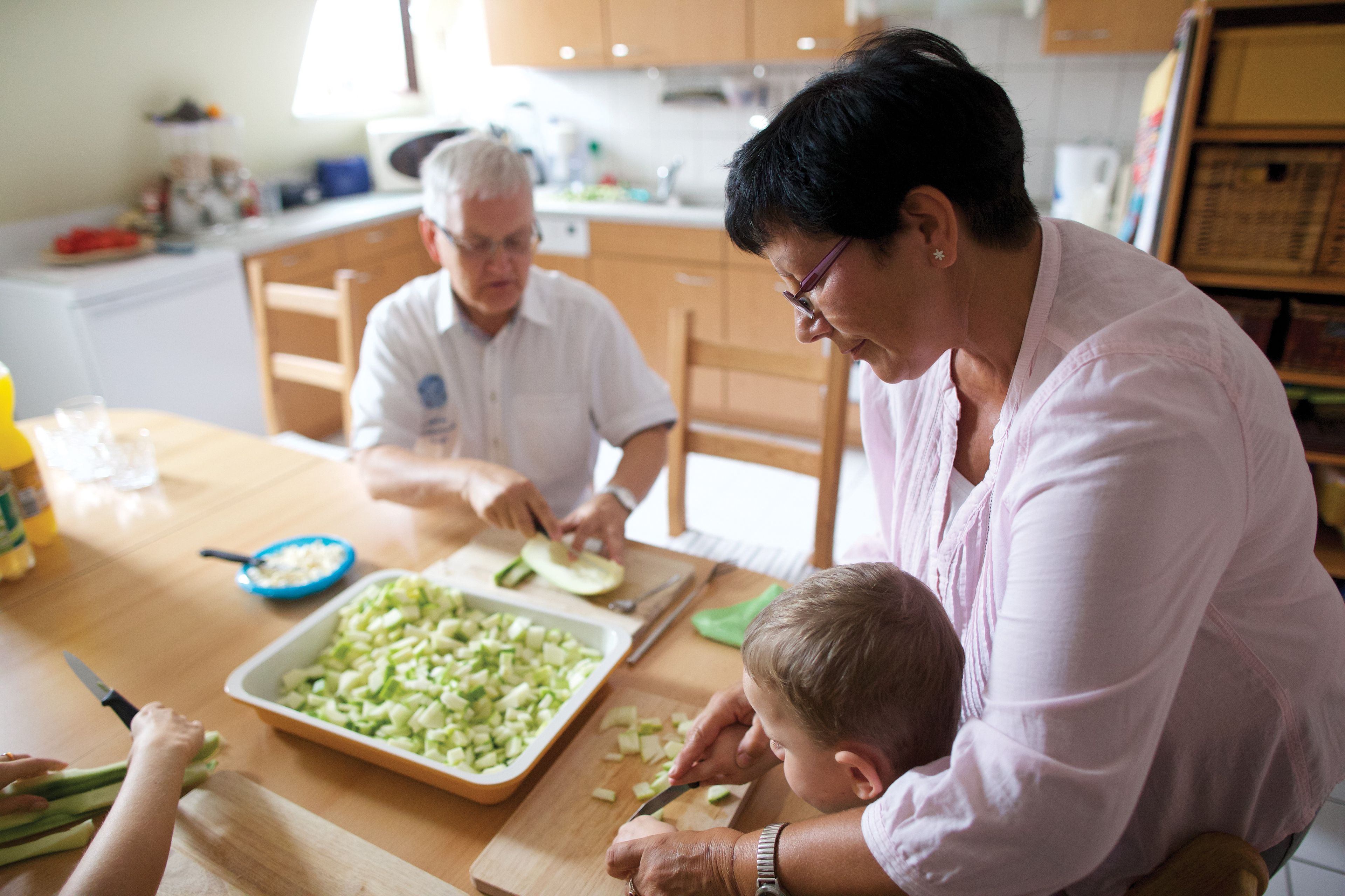 Grandparents help their grandchildren prepare the evening meal.