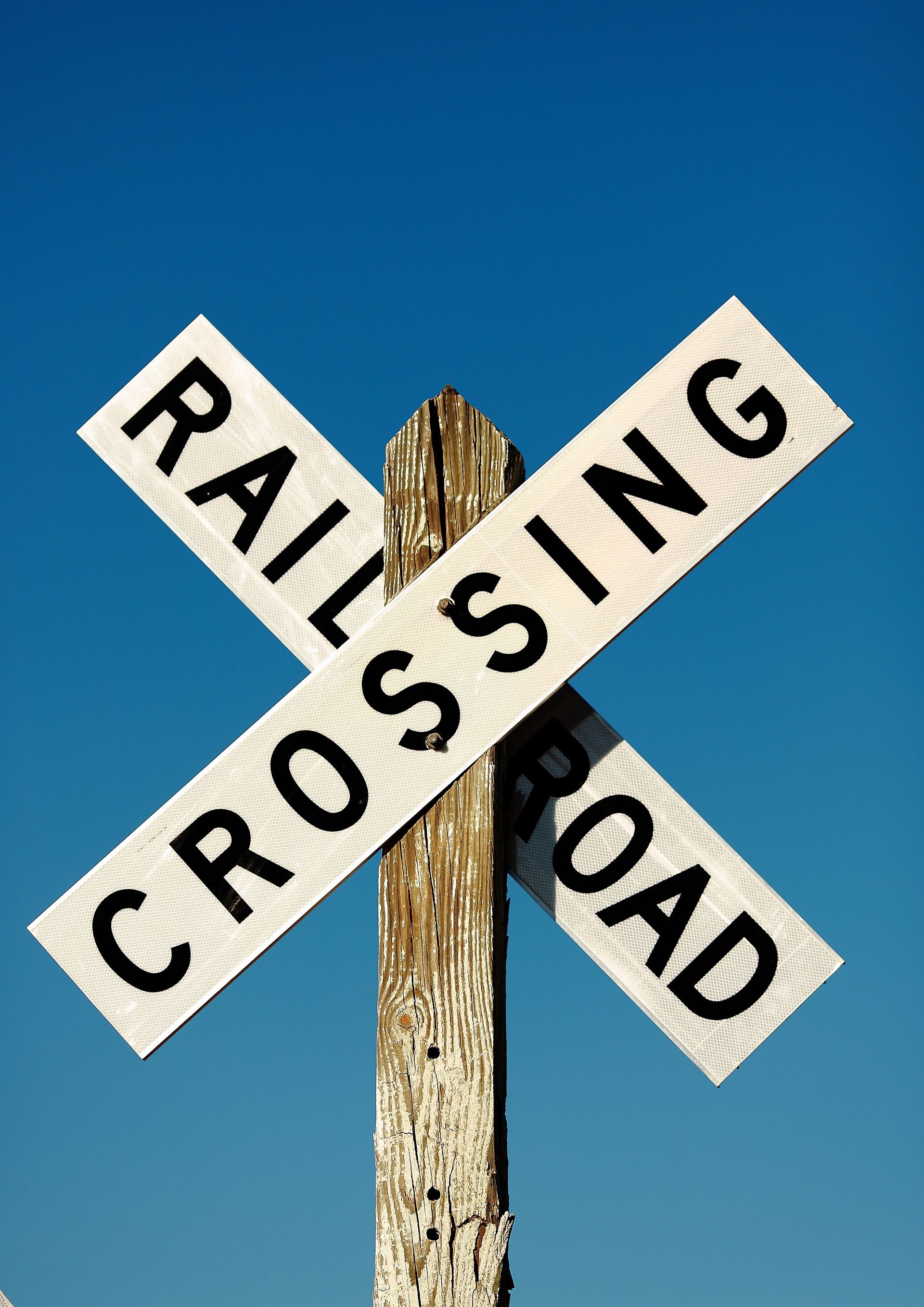 A black and white railroad crossing sign.