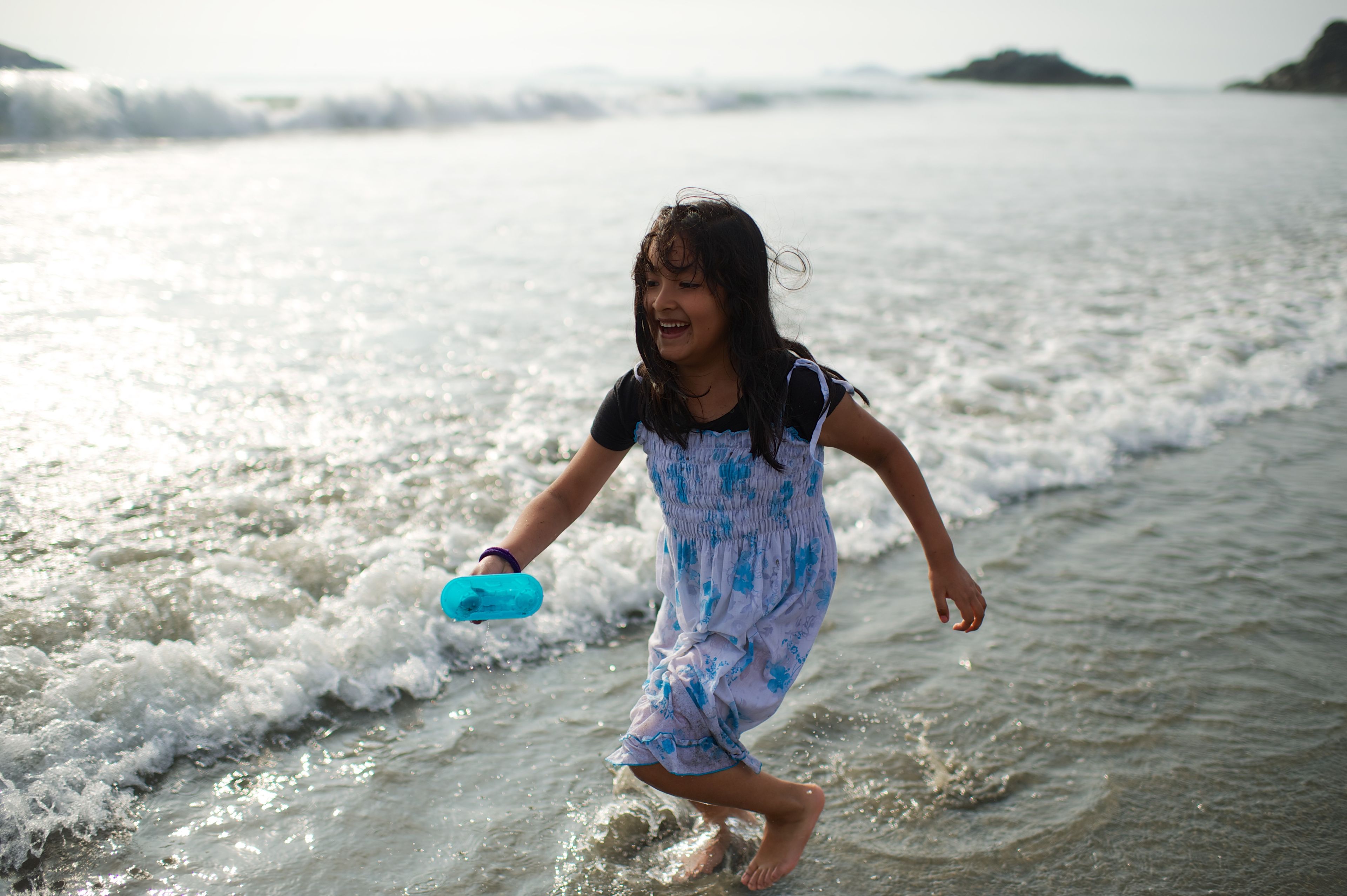 A girl from Peru plays on the beach.  