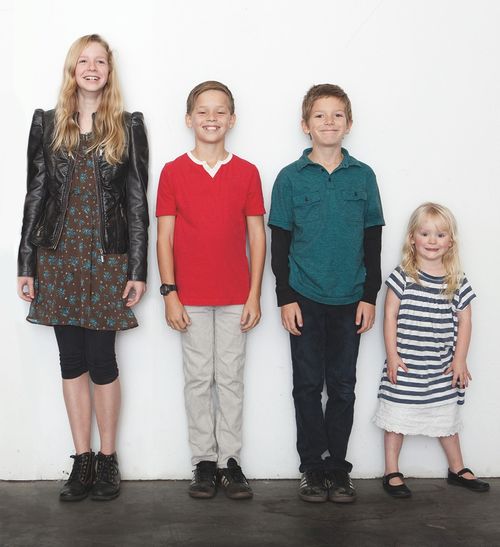 group of siblings in line against white wall