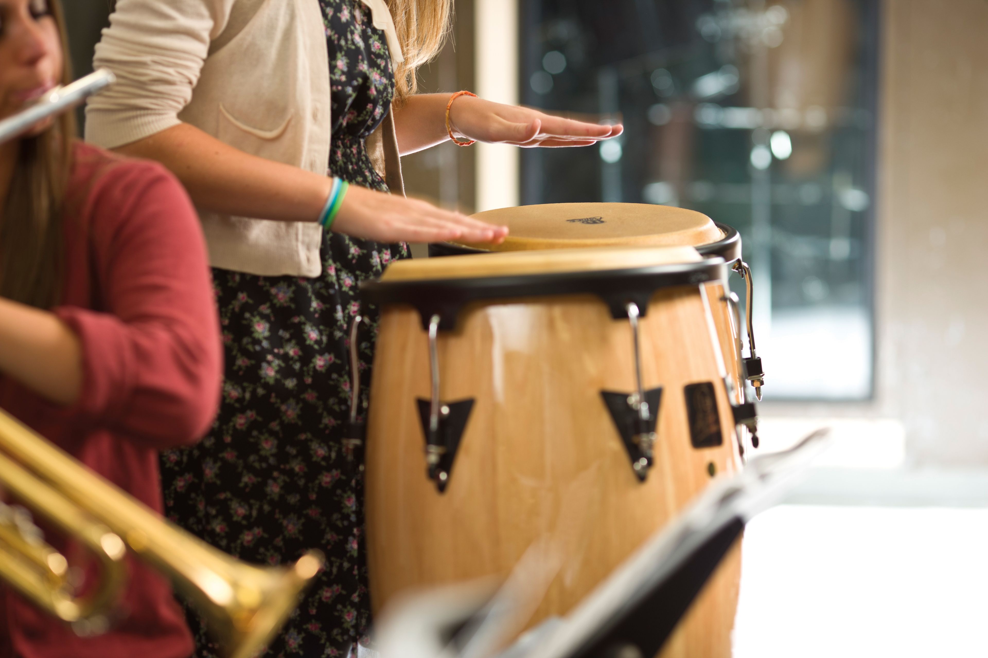Hands are seen playing a drum.