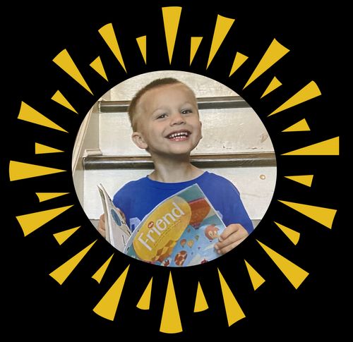 Smiling boy holding copy of the Friend magazine