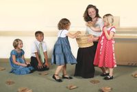 children around teacher with basket