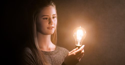 young woman holding lightbulb