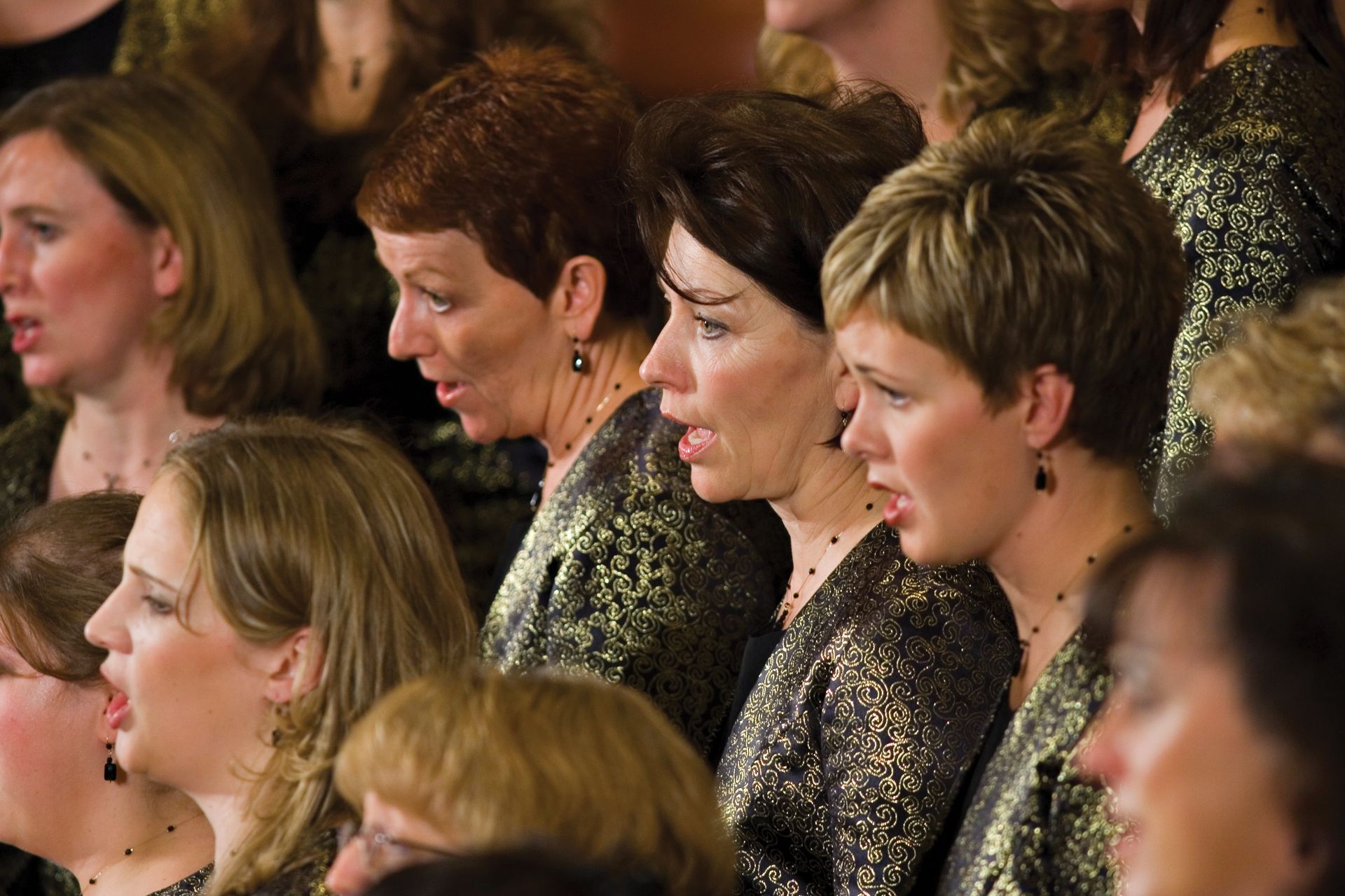 A group of women perform together in a choir.