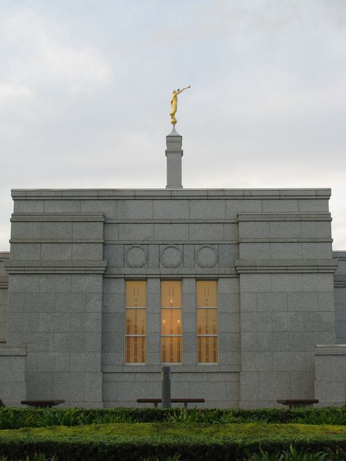 A side view of the exterior of the Adelaide Australia Temple, with the spire and angel Moroni in view.