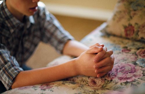 A young man kneeling in prayer.