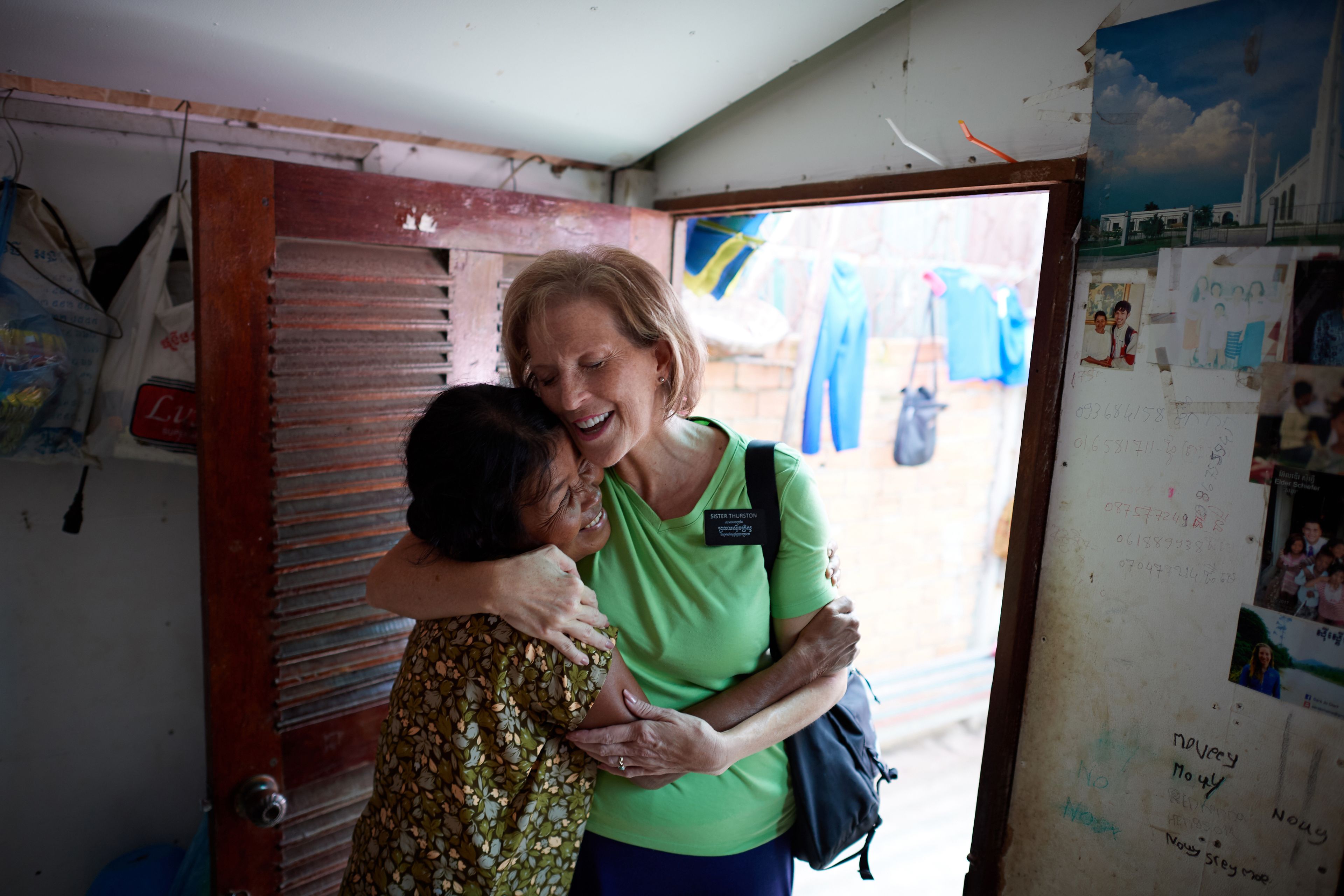A senior sister missionary hugging a woman in Cambodia.