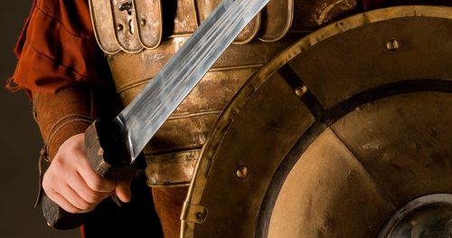 A young man dressed in New Testament era armor with a sword and shield.