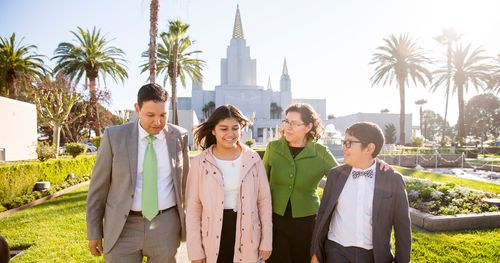 A family spends time together on the grounds in front of the Oakland Temple.