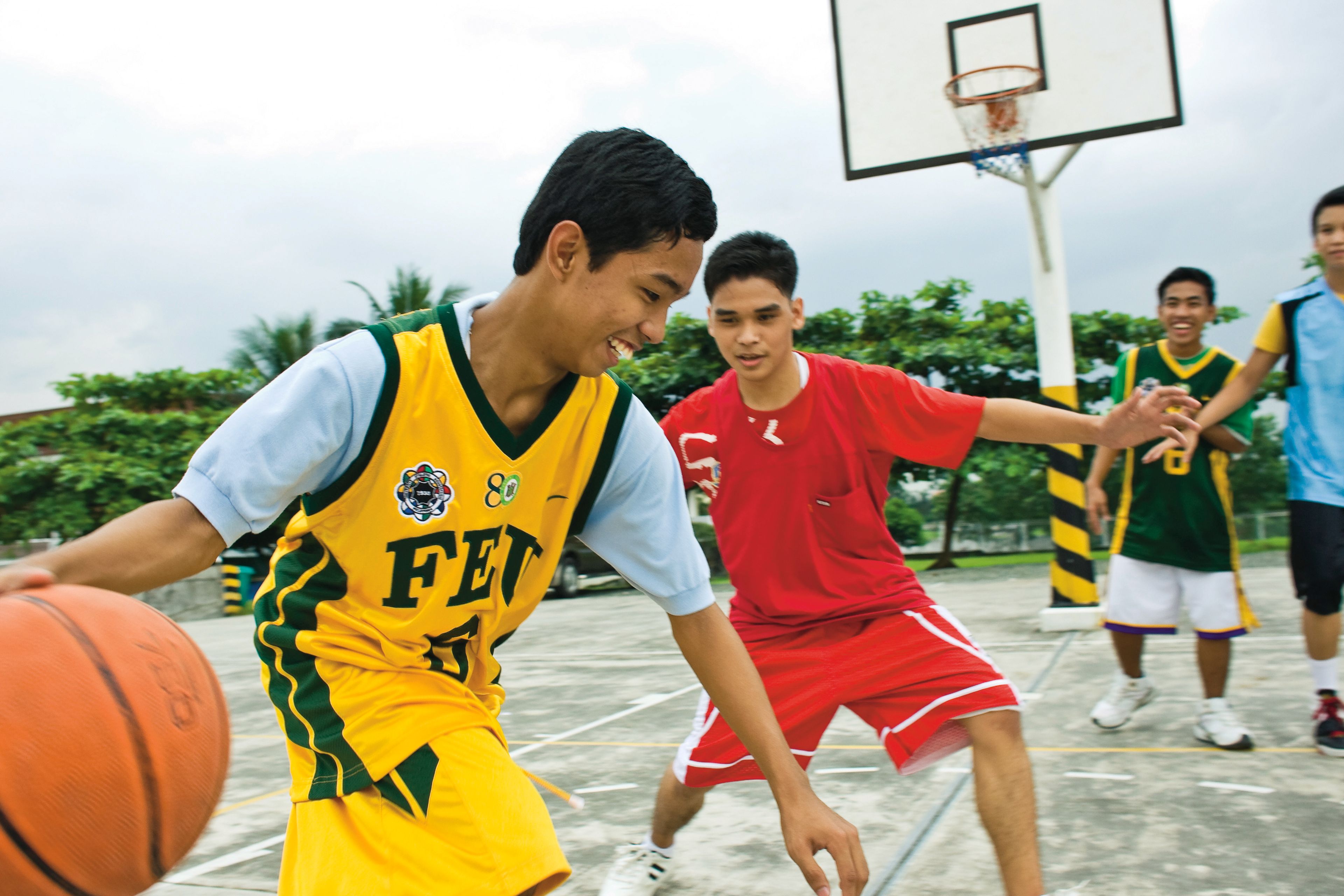 A group of young men playing a game of basketball.