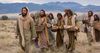 Jesus caminha com os discípulos carregando cestos de pão