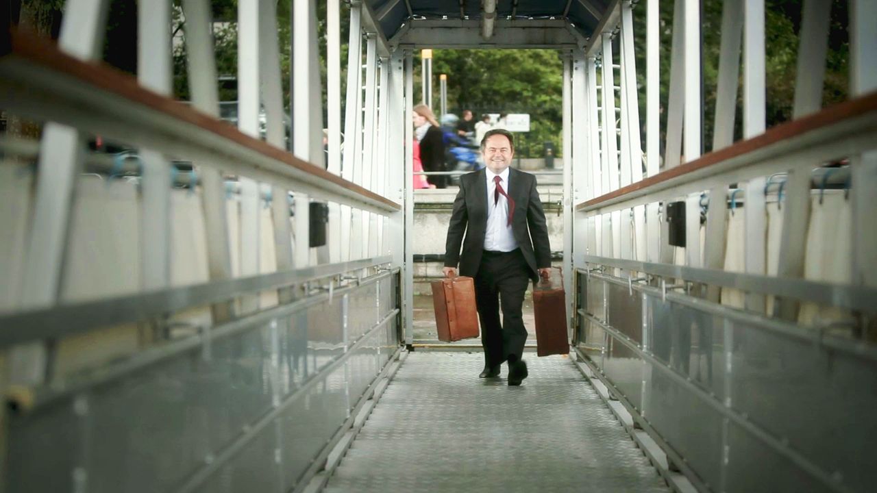 A man walks down a ramp carrying his luggage