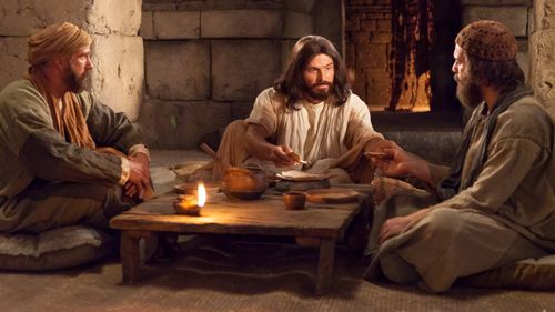 Cleopas and a disciple sitting to eat when they recognize the Savior