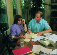 A couple sitting at a table as they look at financial papers and tax forms.