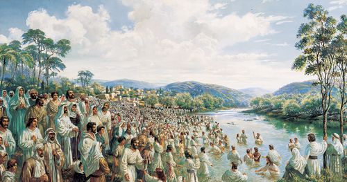 multidão de pessoas à margem do rio enquanto outras são batizadas