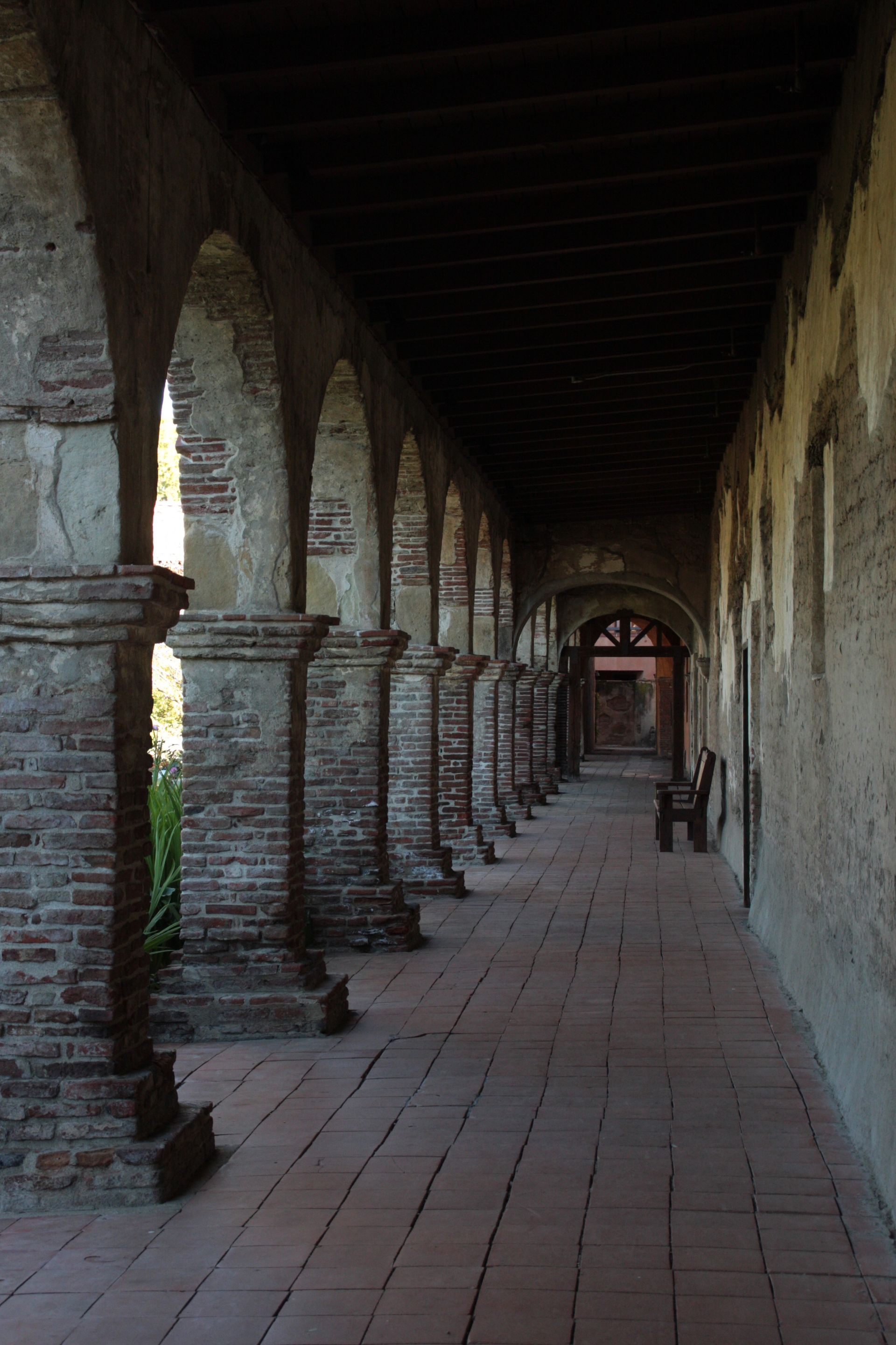 A walkway with arched brick pillars.