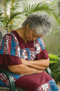 An elderly woman in Fiji praying.