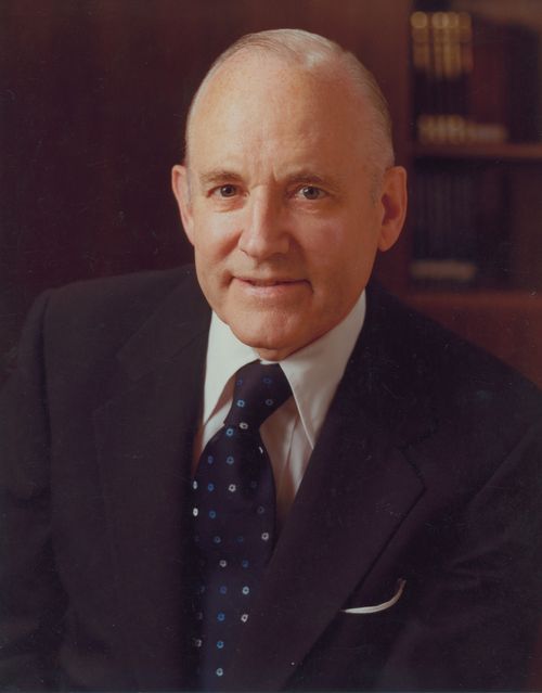 A portrait photograph by Busath Photography of Howard W. Hunter in a dark suit and blue tie.