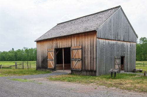 A large wooden barn with the doors wide open on the property of the Smith family farm in Palmyra, New York.