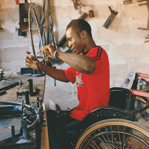 young man in wheelchair at a workbench