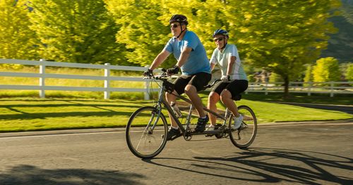 A couple rides their tandem bike for morning exercise.