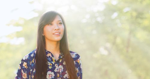 A young adult Asian woman looking forward and upward.