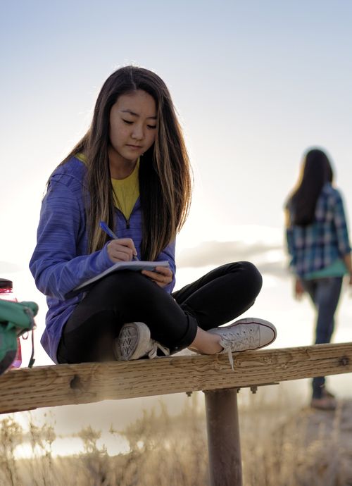 girl writing at camp
