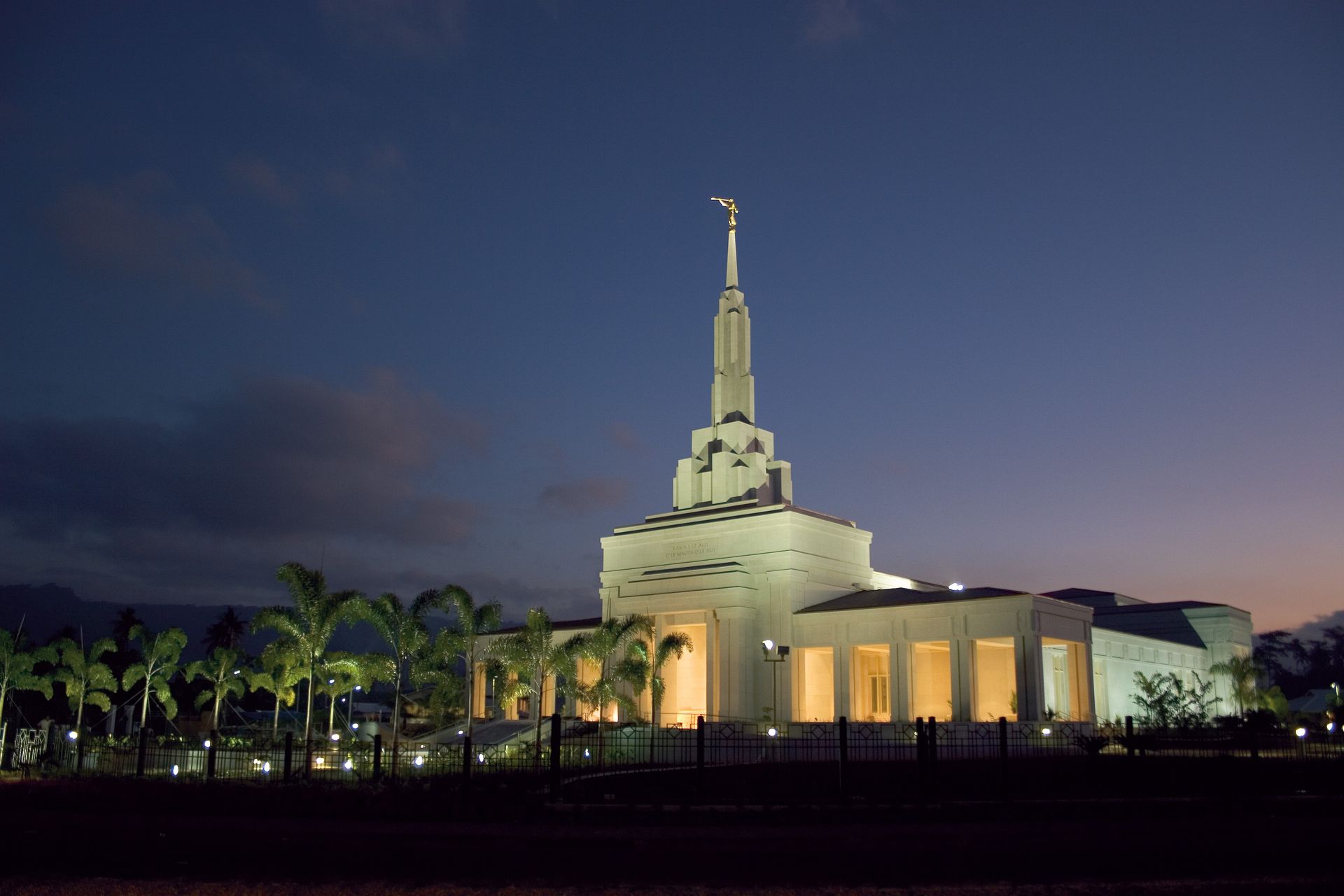 The Apia Samoa Temple and temple grounds are lit up at night.