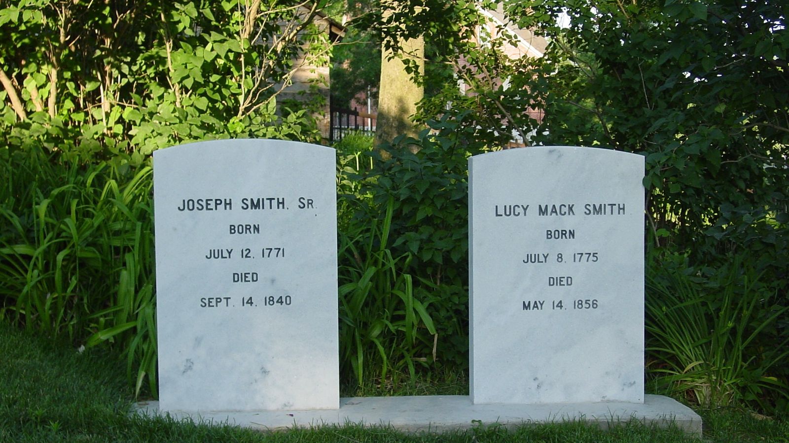 Two white marble headstones for Joseph Smith Sr, and Lucy Mack Smith.