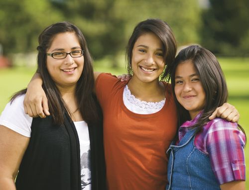 tre smilende unge kvinner