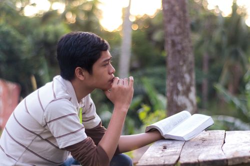 young man pondering over the scriptures