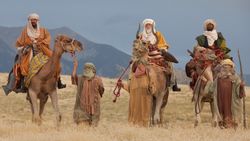 The Wise Men riding on camels travel to Israel to worship the young Jesus Christ