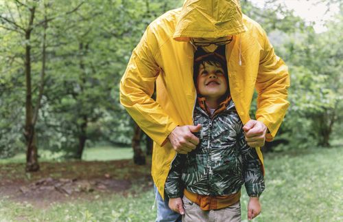 father and son standing in the rain